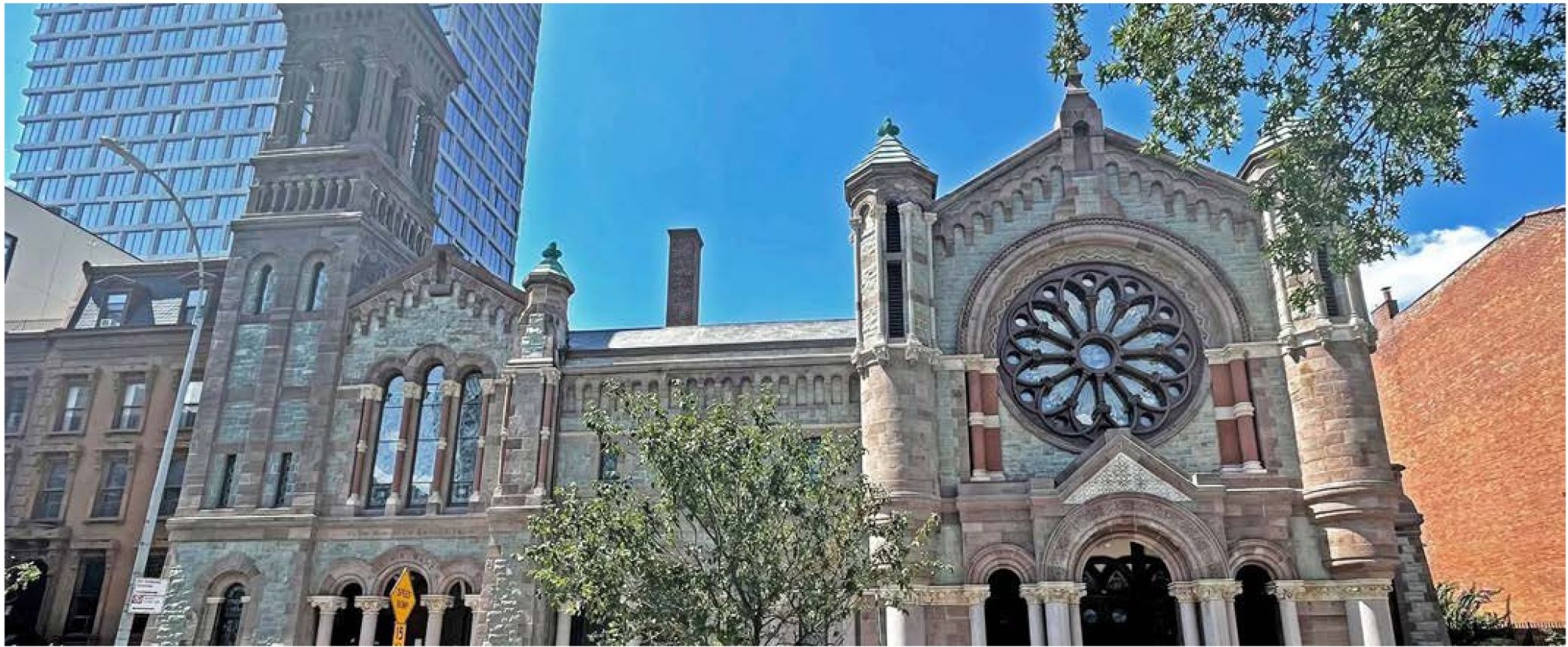 Fully restored Church of St. Luke and St. Matthew standing beside the high-rise development that funded the work