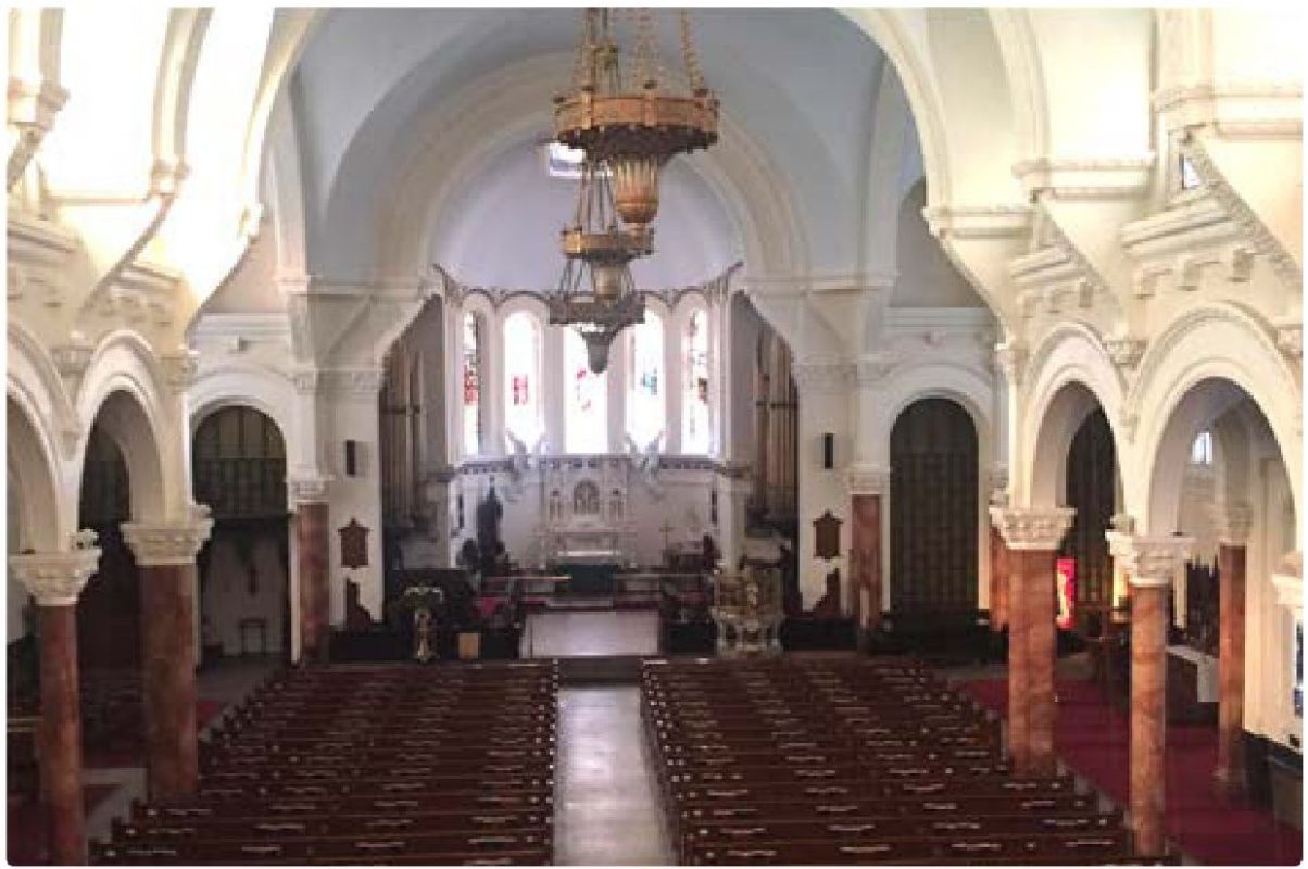Interior of the church sanctuary with pews and marble columns